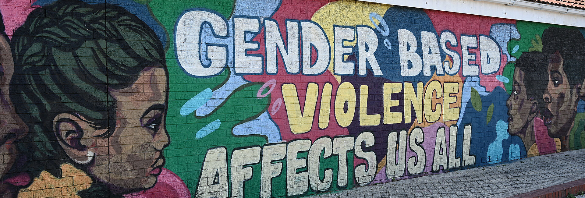 Graffiti an Hauswand mit Slogan gegen geschlechtsspezifische Gewalt.