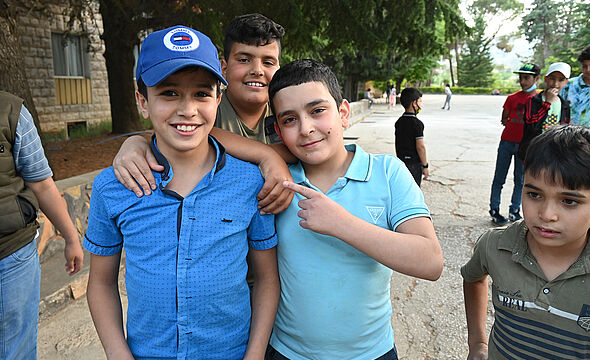 Drei Jungs umarmen sich.