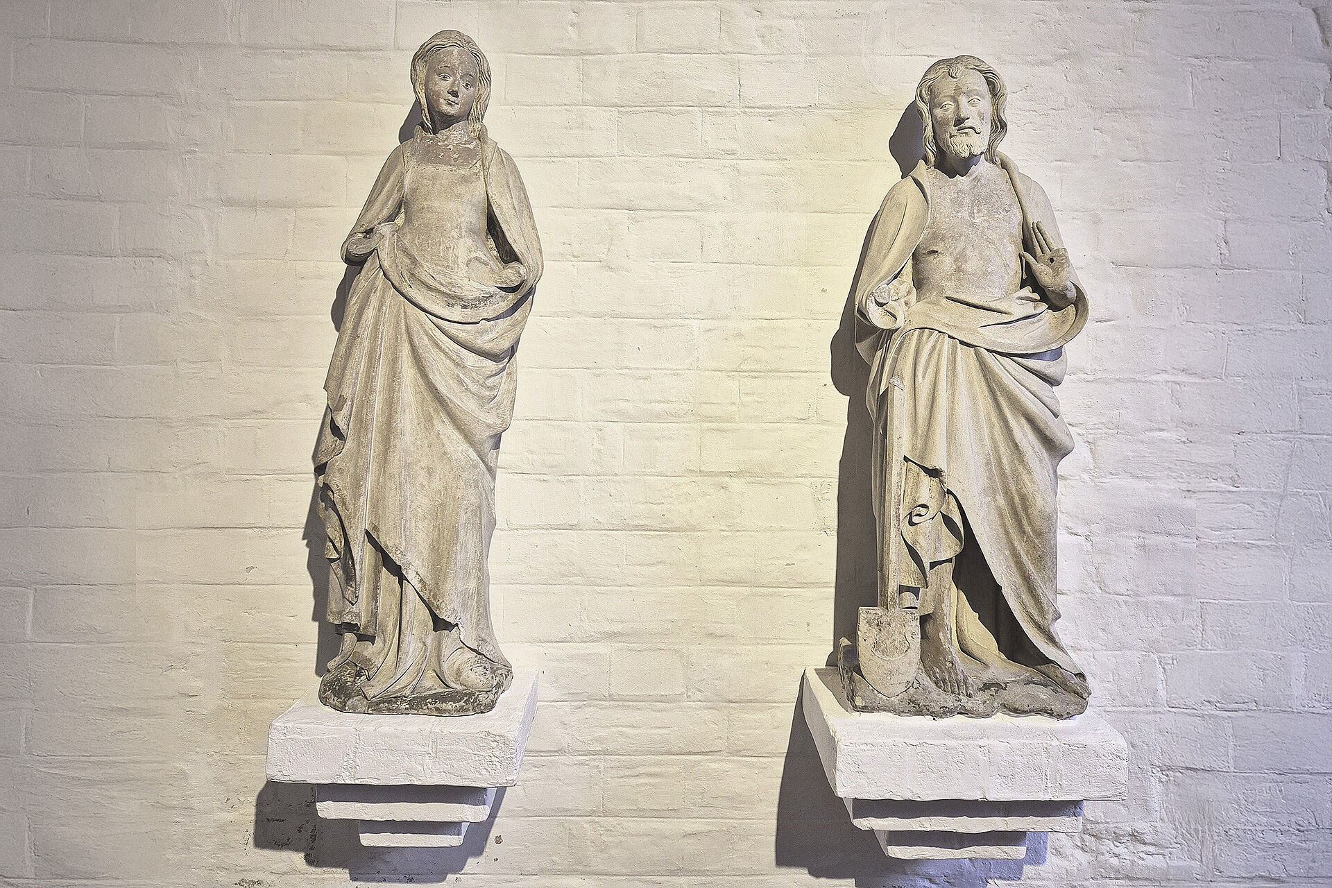 Bild zweier Statuen auf jeweils einem Sockel