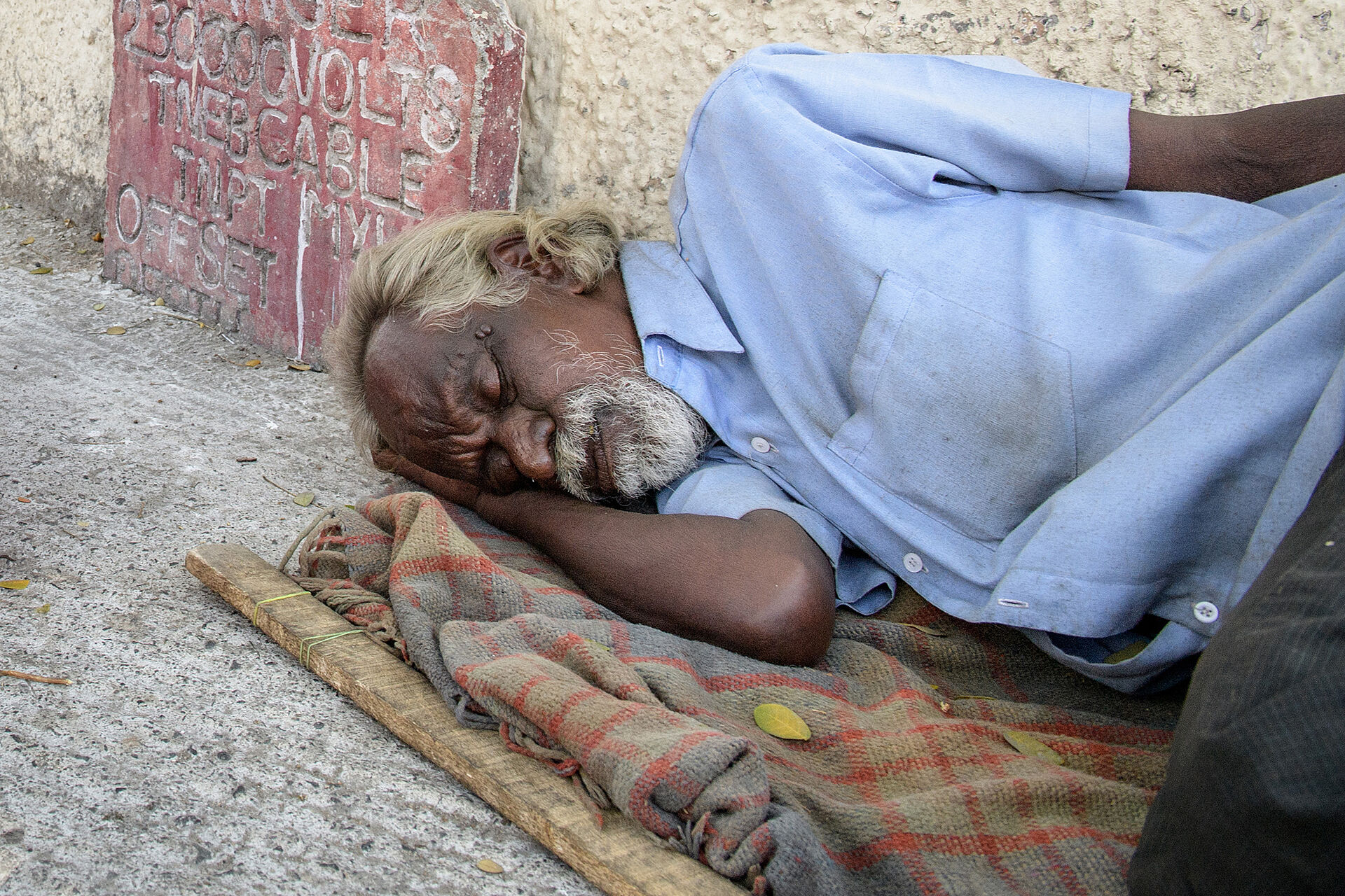 Homeless man from India sleeps on the floor.